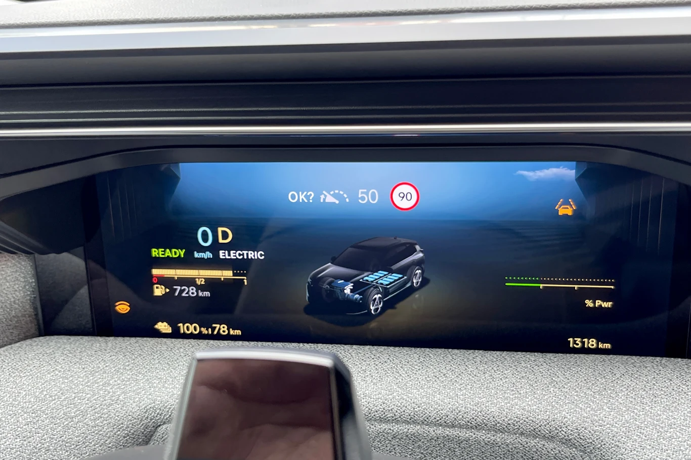 Na w pełni naładowanym akumulatorze udało się nam przejechać blisko 80 km w trybie elektrycznym. Cyfrowy wyświetlacz samochodu elektrycznego prezentuje grafikę pojazdu, aktualną prędkość, zasięg, poziom naładowania baterii oraz limity prędkości.