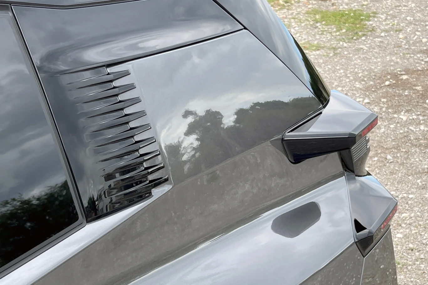 Stylistyka nowego C5 Aircross może się podobać. Jest odważnie i "agresywnie". Czarna karoseria samochodu z widocznymi detalami aerodynamicznymi przy tylnej szybie oraz nowoczesną lampą tylną, odbicia otoczenia widoczne na powierzchni lakieru.