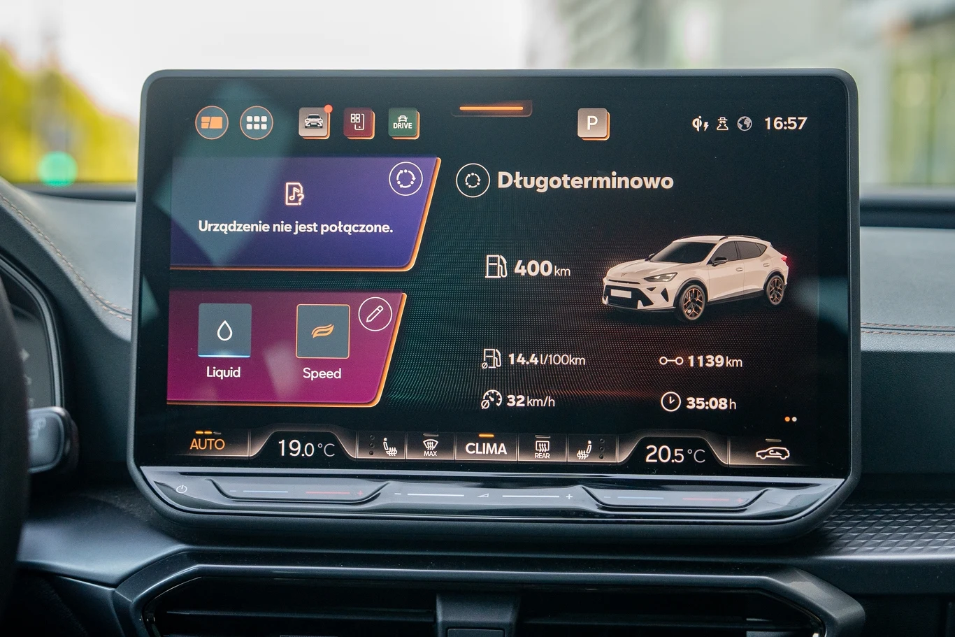 Ekran systemu multimedialnego samochodu z wyświetlanymi informacjami dotyczącymi zasięgu pojazdu, parametrów jazdy, ustawień klimatyzacji oraz połączeń urządzeń.