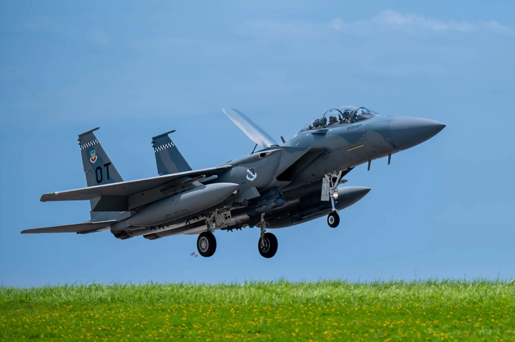 F-15EX to najnowsza modyfikacja serii dwumiejscowych myśliwców wielozadaniowych. Wykorzystuje nową awionikę, mającą dawać platformie sięgającej lat 70. możliwości równe najnowszym samolotom bojowym Wojskowy myśliwiec odrzutowy w trakcie startu nad zieloną łąką na tle niebieskiego nieba.
