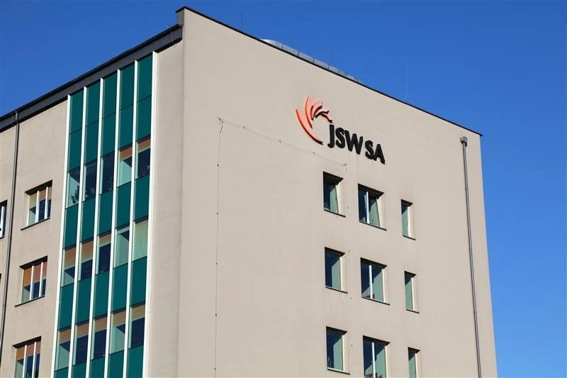 Prezes zarządu JSW został odwołany Nowoczesny budynek biurowy z logo JSW SA na jasnej elewacji, wyraźnie widoczne duże okna i prosta architektura, w tle bezchmurne, niebieskie niebo.