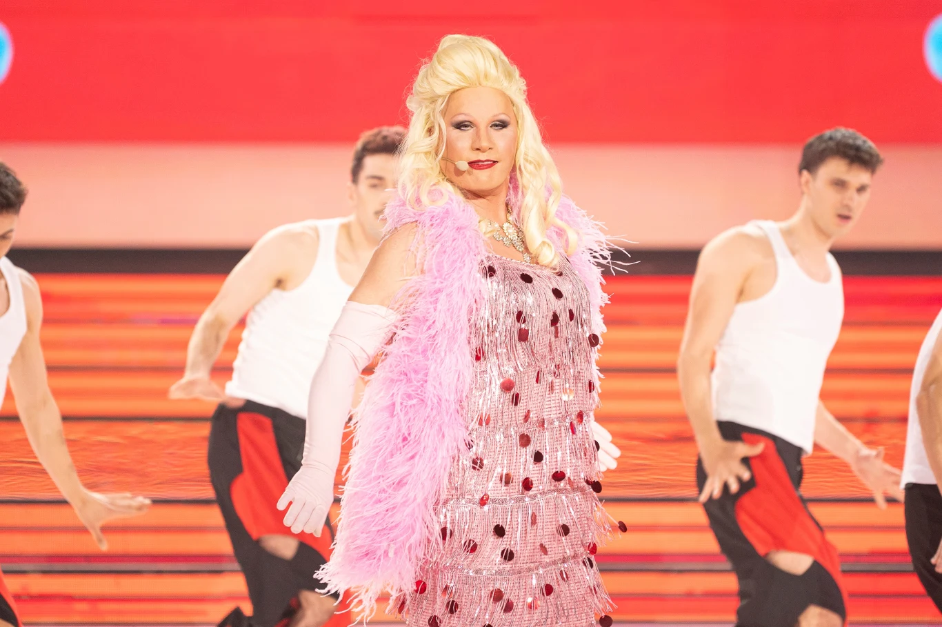 Andrzej Nejman wcielił się w Billy'ego More'a Osoba w efektownej, błyszczącej kreacji ozdobionej piórami i cekinami, w otoczeniu tancerzy ubranych w białe podkoszulki i czarne spodnie z czerwonym akcentem. Na pierwszym planie dominuje mocny makijaż oraz charakterystyczna fryzura blond.