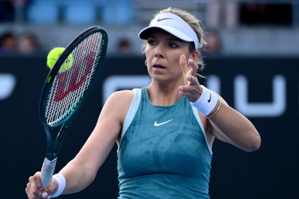 Katie Boulter Kobieta w sportowym stroju grająca w tenisa, skupiona na odbiciu piłki rakietą tenisową, widoczna dynamiczna akcja na korcie.