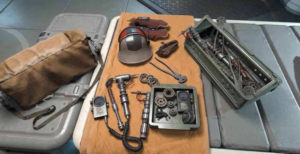 Star Wars: Knights of the Old Republic - grafika koncepcyjna Rozłożone narzędzia techniczne, części mechaniczne, skrzynka z narzędziami, torba materiałowa, hełm ochronny oraz rękawice leżące na materacu w technicznym, sterylnym otoczeniu.