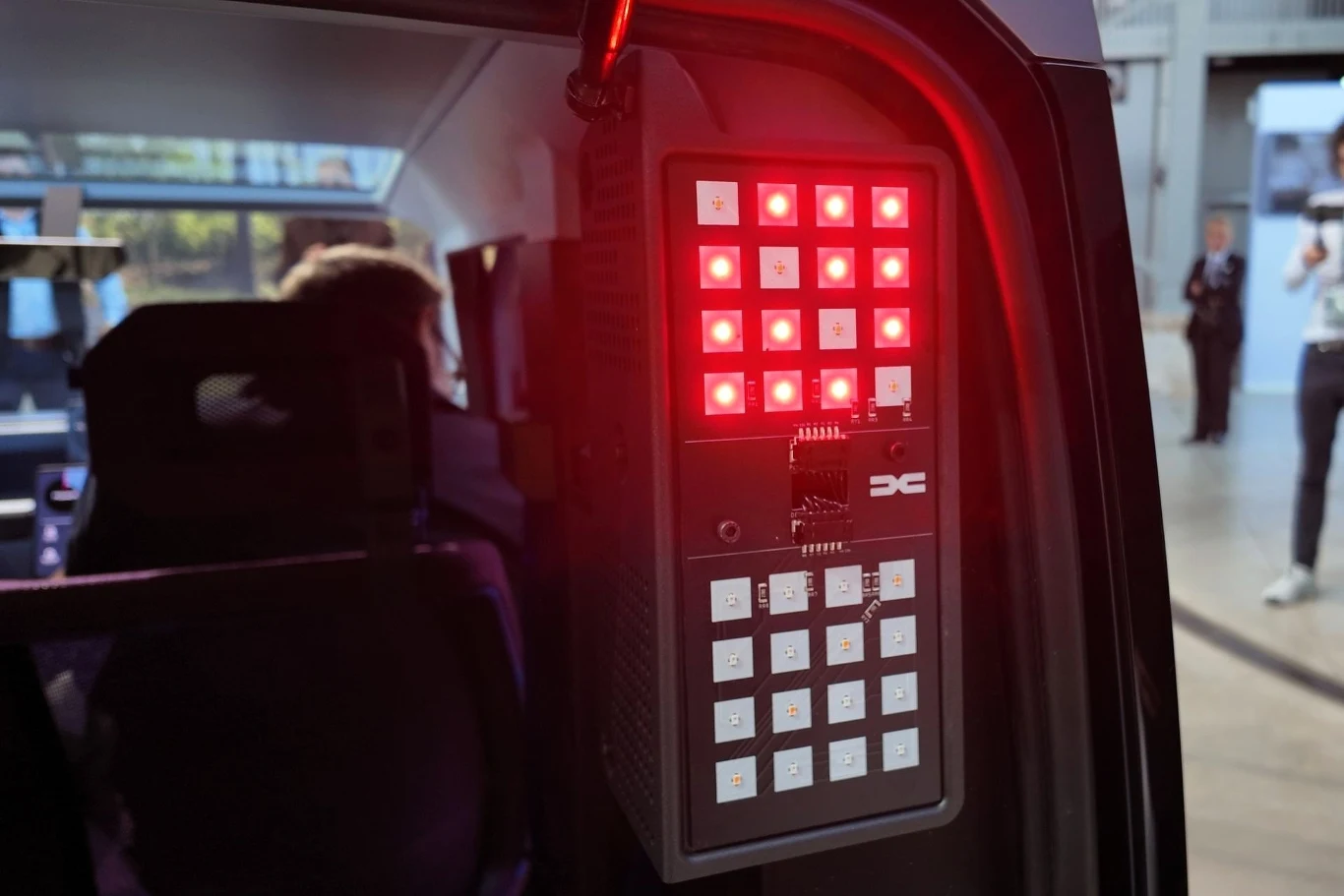 W celu optymalizacji kosztów tylne światła umieszczono za szybą klapy bagażnika. Dzięki temu nie potrzeba im indywidualnego przeszklenia. Panel z licznymi świecącymi się na czerwono i biało kontrolkami technicznymi zamontowany we wnętrzu pojazdu, w tle widoczne sylwetki ludzi oraz fragmenty hali wystawowej.