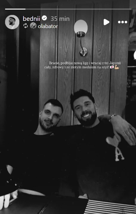 Bartosz Bednorz (L) pożegnał wyjeżdżającego do Japonii Norberta Hubera (P) Dwóch mężczyzn siedzi razem przy stole w restauracji, obaj uśmiechnięci, jeden obejmuje drugiego ramieniem, w tle widać drewnianą ścianę oraz lampę ścienną, atmosfera jest przyjacielska i swobodna.