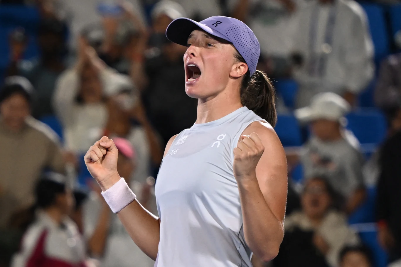 Iga Świątek poznała swoją rywalkę w drugiej rundzie WTA 1000 w Wuhan Zawodniczka tenisa wyrażająca radość i emocje po zwycięstwie, ubrana w sportowy strój, z zaciśniętymi pięściami, w tle widownia kibicująca uczestnikom meczu.