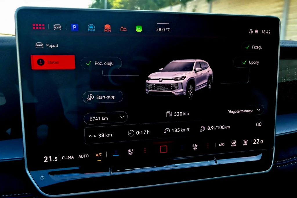 Ekran dotykowy w samochodzie prezentujący szczegółowe informacje o stanie pojazdu, takie jak poziom oleju, zużycie paliwa, przebieg, ciśnienie w oponach oraz inne parametry techniczne, z graficzną wizualizacją auta.