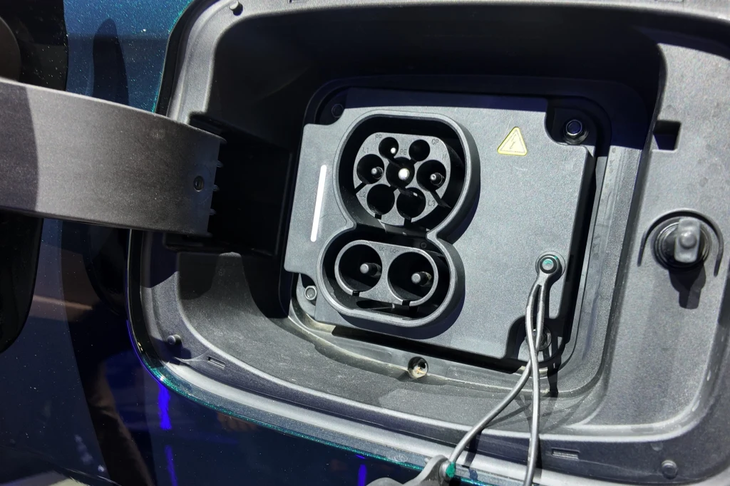 Akumulator o pojemności 34,46 kWh można naładować prądem stałym z poziomu 30 do 80 proc. w 18 minut. Port ładowania samochodu elektrycznego z widocznymi złączami i zamknięciem ochronnym, na obudowie znajduje się znak ostrzegawczy o wysokim napięciu.