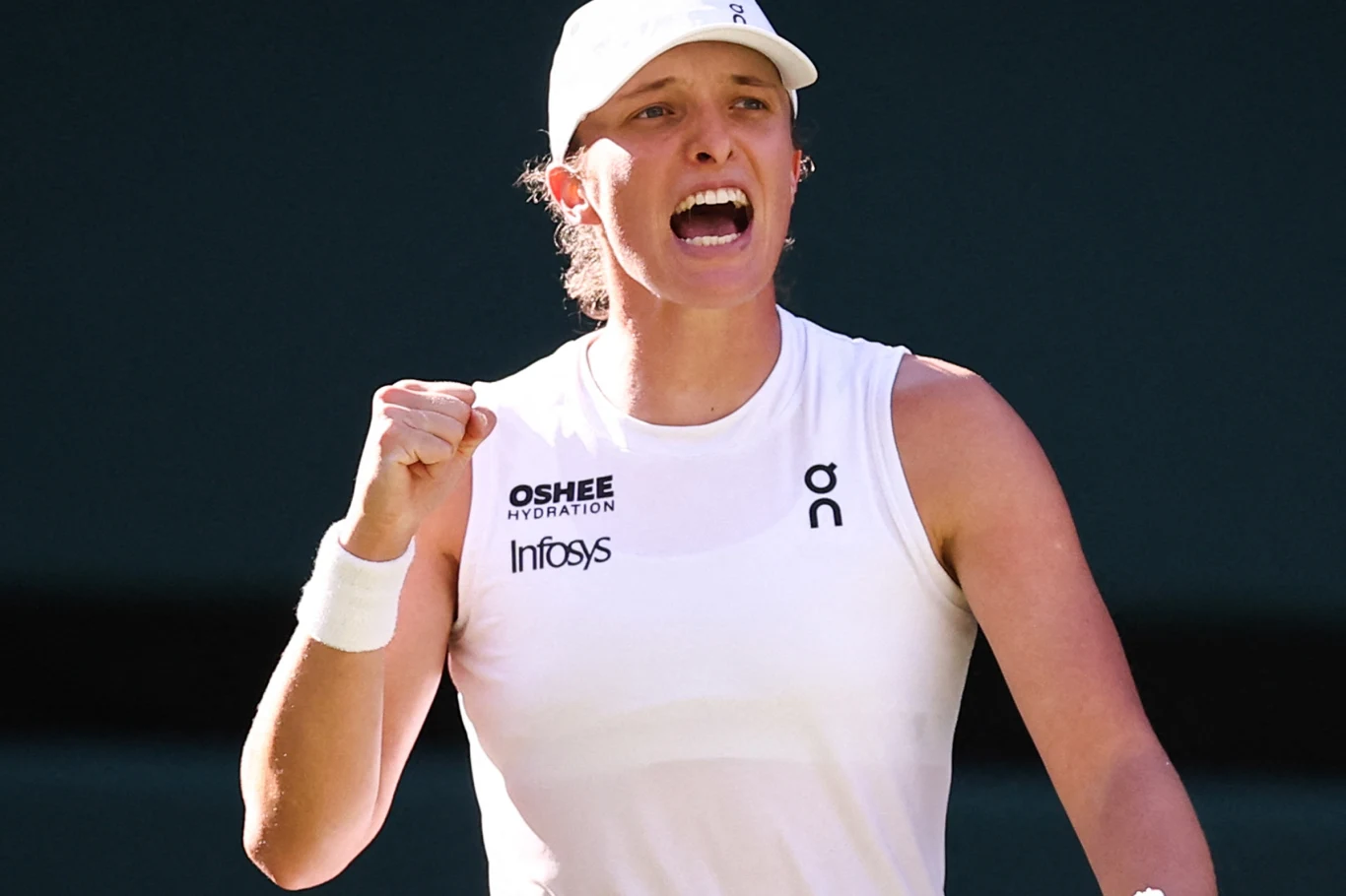 Zawodniczka tenisowa w białym stroju sportowym z zaciśniętą pięścią i wyrazem determinacji na twarzy, dynamiczna poza sugerująca moment po udanej akcji na korcie.