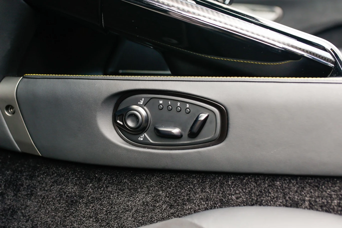 Fotele wyposażone są w elektryczne sterowanie. Panel sterowania elektrycznym fotelem samochodowym, wyposażony w przyciski regulacji położenia siedzenia i oparcia, otoczony tapicerką z tworzywa sztucznego oraz elementami wykończenia wnętrza pojazdu.