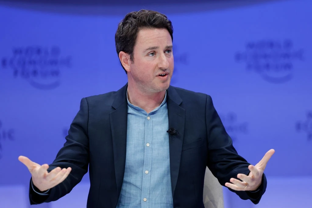 Gabriel Zucman jest jednym z tych, którzy proponują podatek majątkowy Mężczyzna w marynarce i niebieskiej koszuli gestykuluje podczas dyskusji na tle niebieskiej scenografii z napisem World Economic Forum.