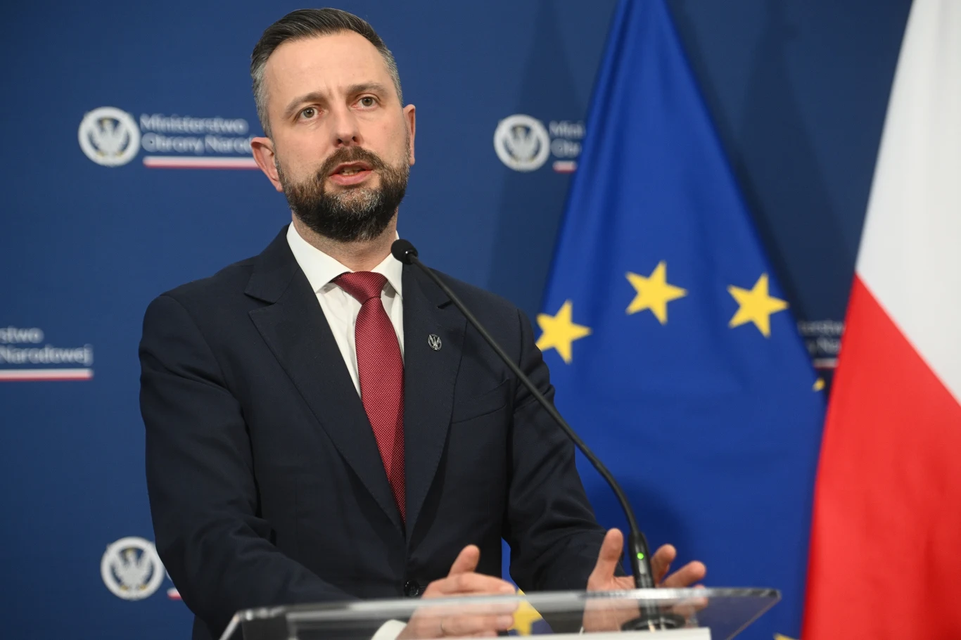 Szef PSL Władysław Kosiniak-Kamysz wyjaśnia: Z Lewicą nie rozmawialiśmy o ustawie o związkach partnerskich Mężczyzna w garniturze przemawia na mównicy na tle flagi Unii Europejskiej oraz Polski, oficjalne otoczenie wskazuje na konferencję prasową lub wystąpienie polityczne.