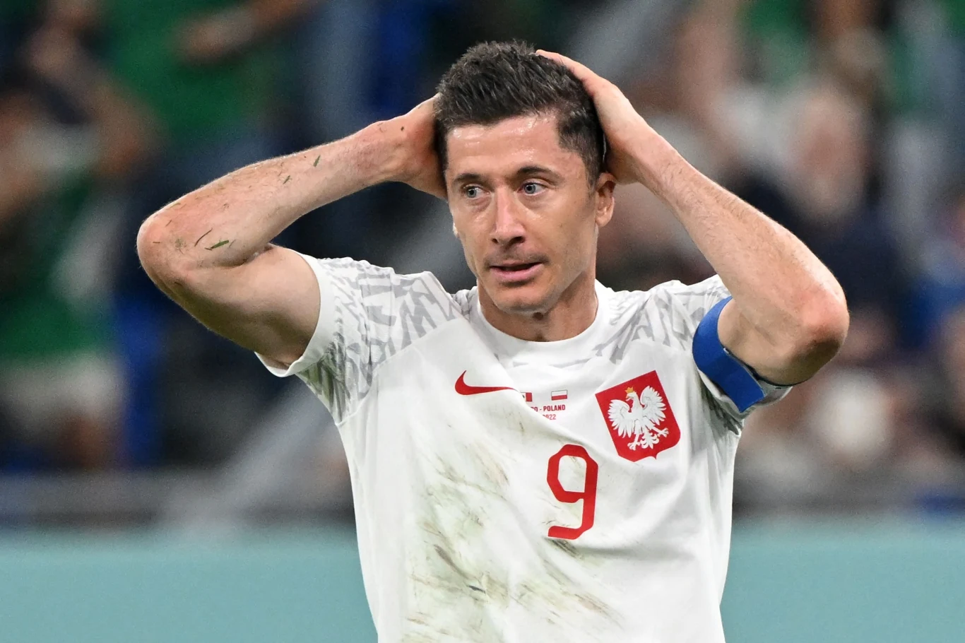 Robert Lewandowski najpewniej zakończy piłkarską karierę przed rokiem 2035 Piłkarz w białej koszulce z numerem 9 i z orłem na piersi trzyma ręce na głowie, wyrażając emocje, na ramieniu opaska kapitana, w tle rozmazana publiczność stadionowa.