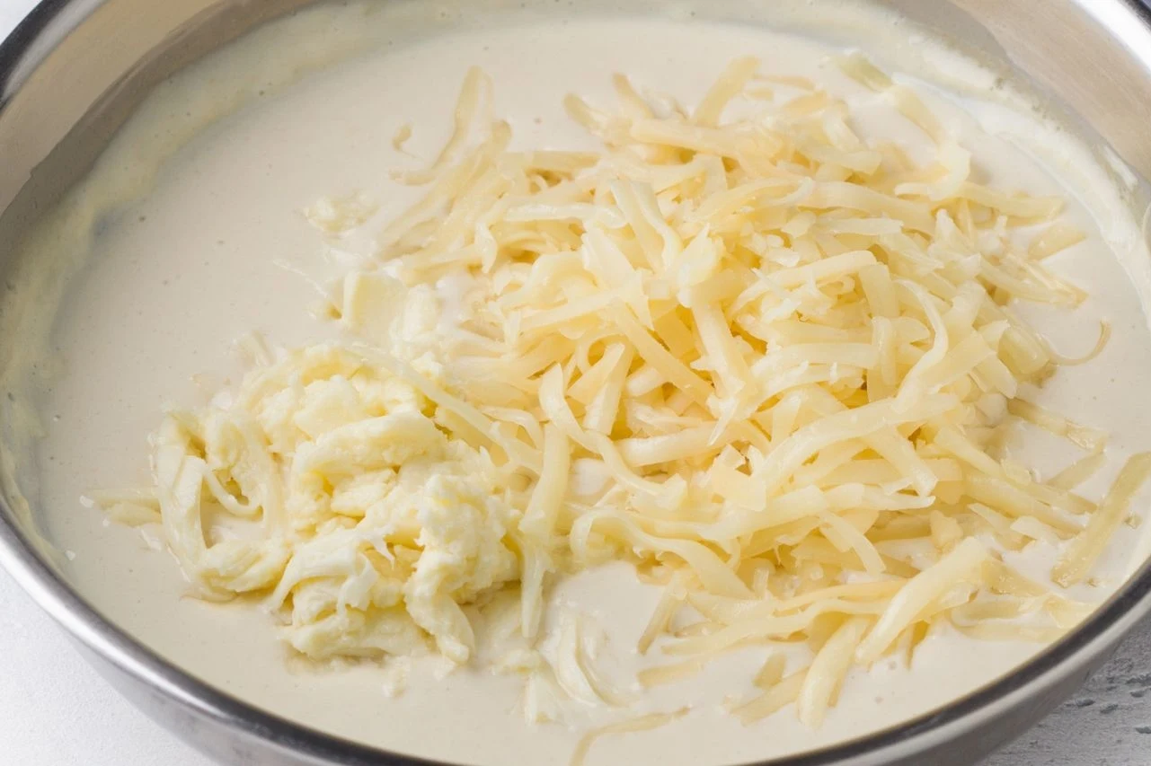Gęsty sos powstaje z jajek, śmietany, przypraw i startego sera. Wymieszaj do połączenia