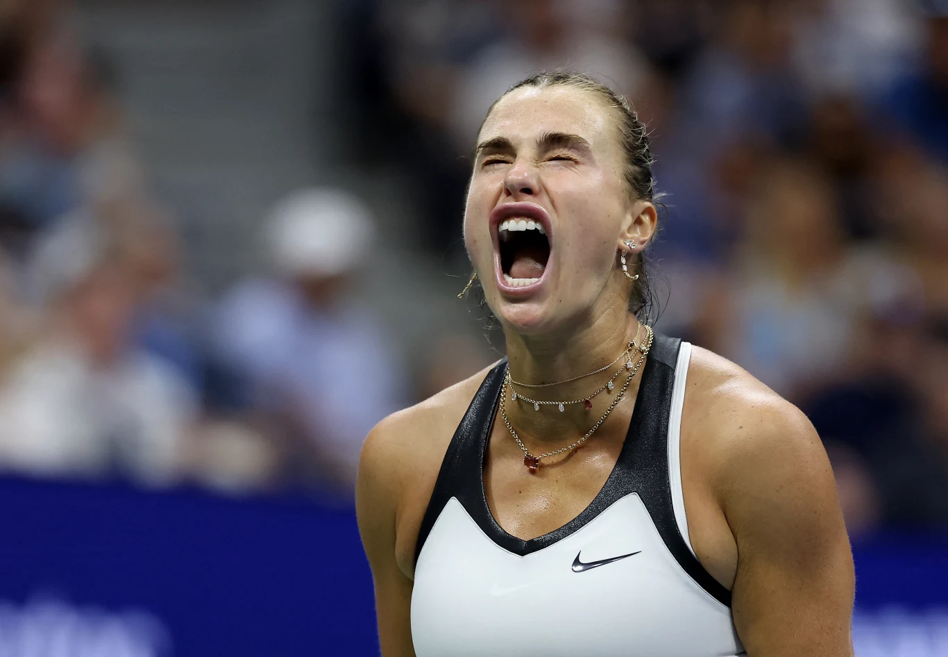 Aryna Sabalenka najlepszą tenisistką świata w 2025 roku Zawodniczka tenisowa w sportowym stroju krzyczy z szeroko otwartymi ustami, wyrażając silne emocje i napięcie podczas meczu, w tle rozmyty tłum kibiców.