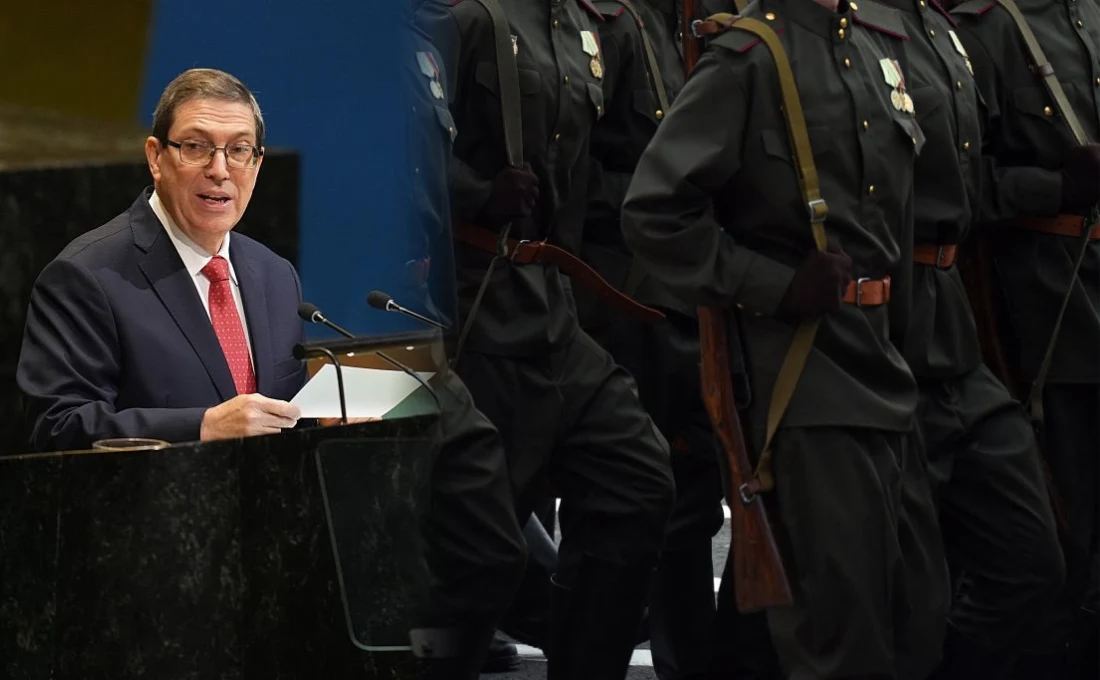 Kubańskie MSZ reaguje na oskarżenia o udział w wojnie w Ukrainie Mężczyzna w garniturze przemawia przy mównicy, obok maszerują żołnierze w czarnych mundurach z odznaczeniami, widoczne są karabiny przewieszone przez ramię.