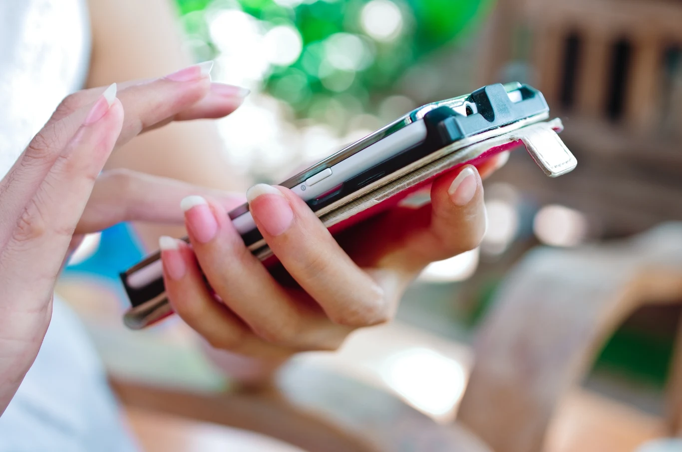 Koniec oferty Heyah. Numery klientów zostaną przeniesione Dłoń trzymająca kilka smartfonów, zbliżenie na palce dotykające ekranów, w tle rozmyte naturalne kolory.