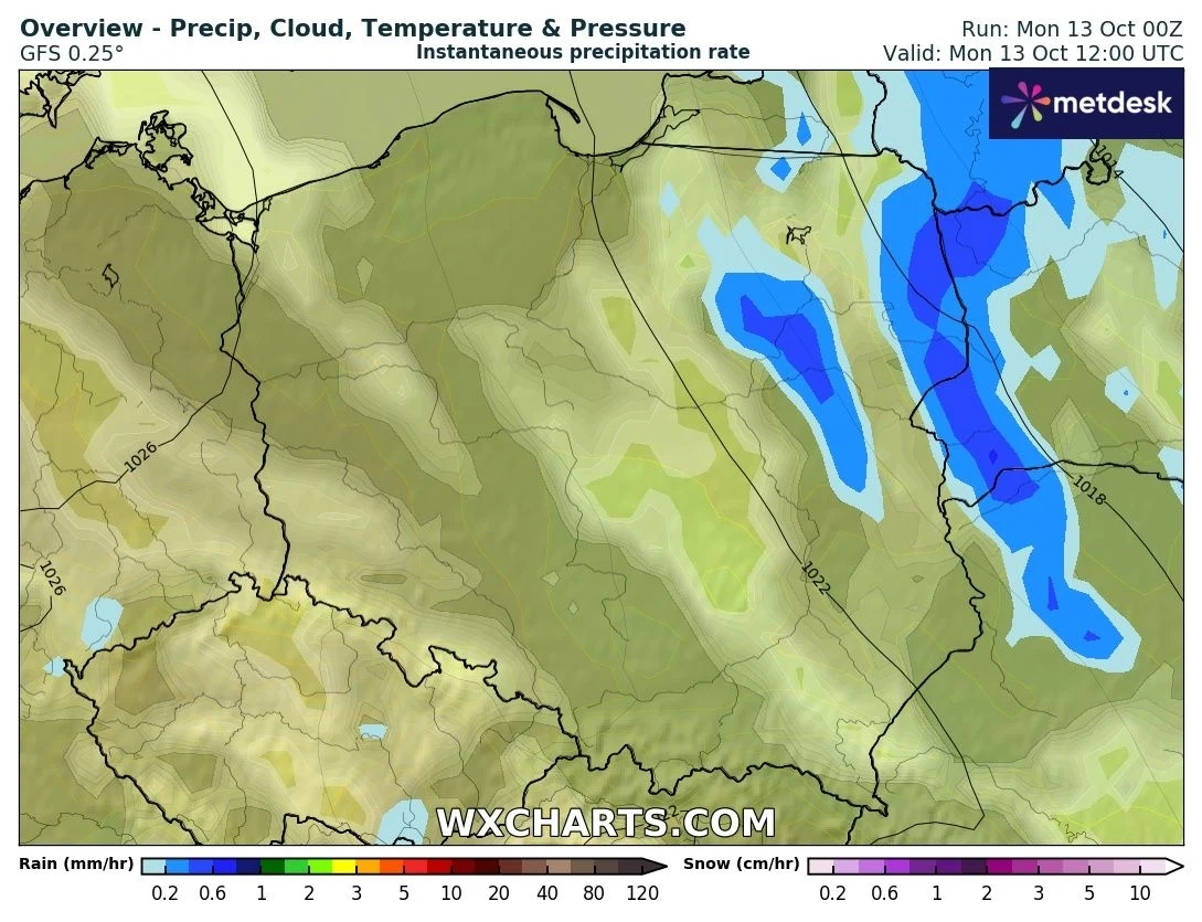 Mapa synoptyczna Polski z oznaczeniem rozkładu opadów, gdzie intensywniejsze opady deszczu uwidocznione są w formie niebieskich plam, głównie w północno-wschodniej części kraju.