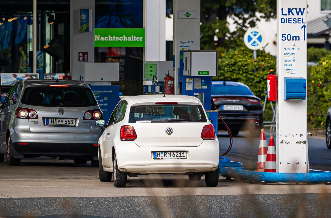Stacje paliw w Niemczech w coraz gorszym stanie. Raport TUV. Samochody zaparkowane przy dystrybutorach paliwa na nowoczesnej stacji benzynowej, widoczne znaki informacyjne, automaty płatnicze oraz elementy infrastruktury takie jak słupek bezpieczeństwa.