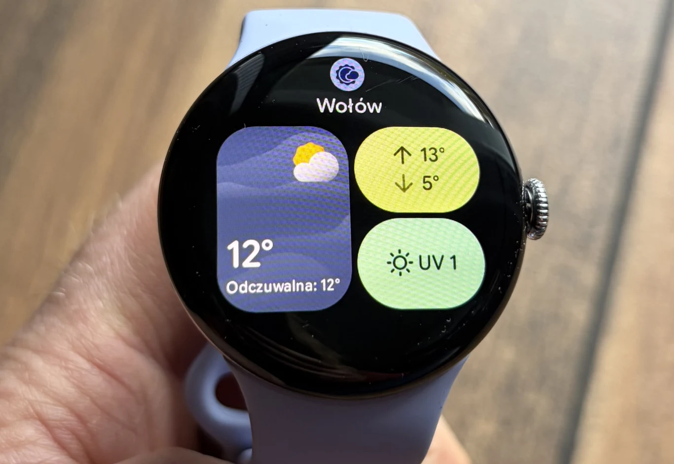 Google Pixel Watch 4 to bardzo udany smartwatch. Inteligentny zegarek na nadgarstku wyświetlający aktualną pogodę w Wołowie, temperatura 12 stopni, informacje o odczuwalnej temperaturze, prognozowana maksymalna i minimalna temperatura oraz wskaźnik UV.