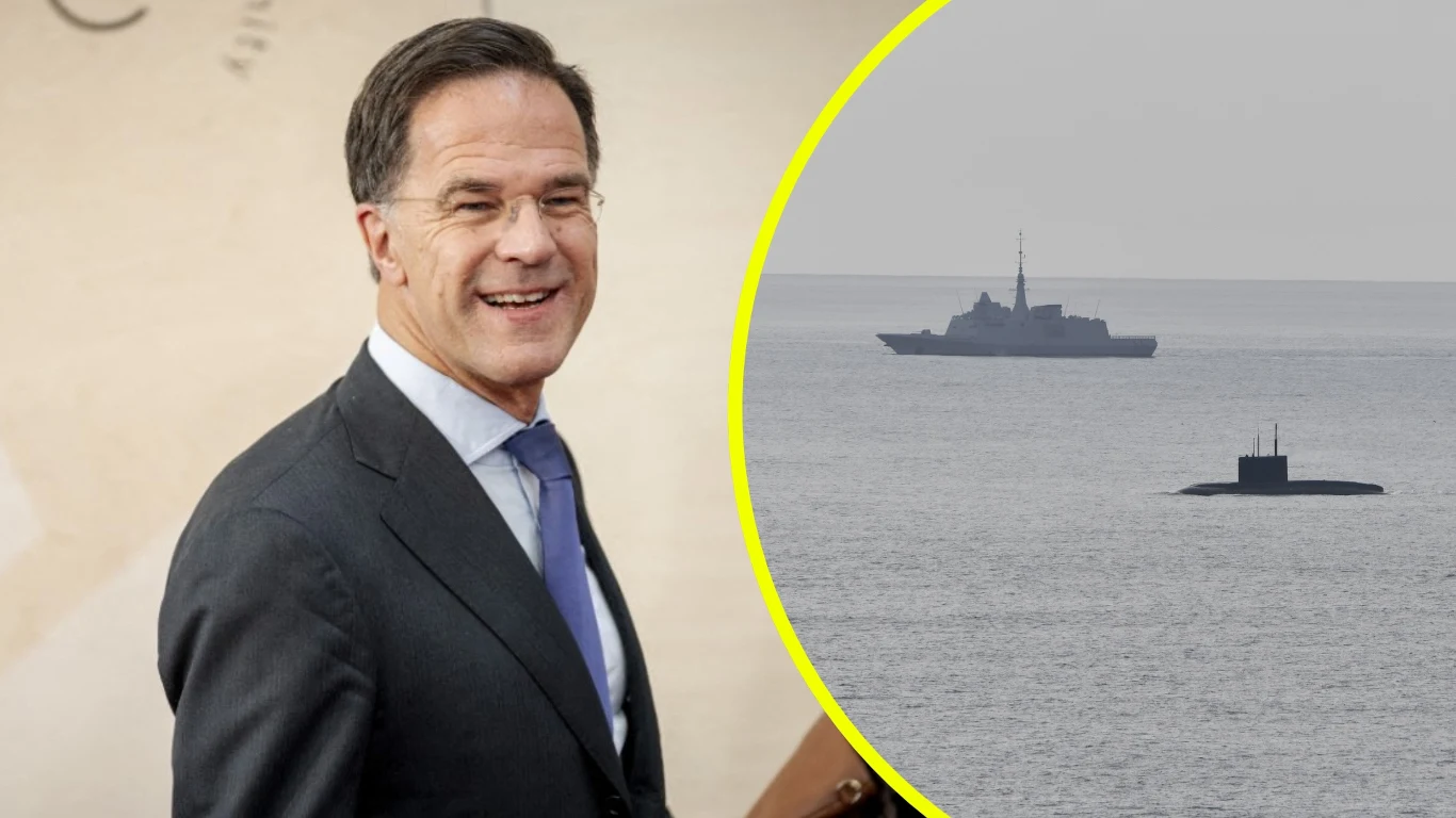 Mark Rutte kpi z rosyjskiego okrętu podwodnego. Rosja zaprzecza, że doszło do awarii Mężczyzna w garniturze z uśmiechem na twarzy, a na drugim planie w okręgu wyodrębniony widok na morze z okrętem wojennym i wynurzonym okrętem podwodnym.