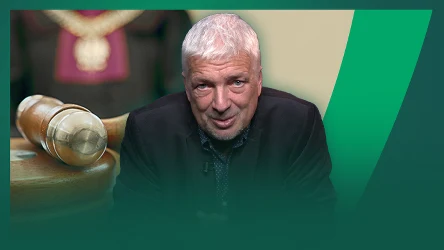 Starszy mężczyzna o siwych włosach w ciemnej marynarce, w tle złoty młotek sędziowski oraz fragment osoby w todze z ozdobnym łańcuchem sądowym.