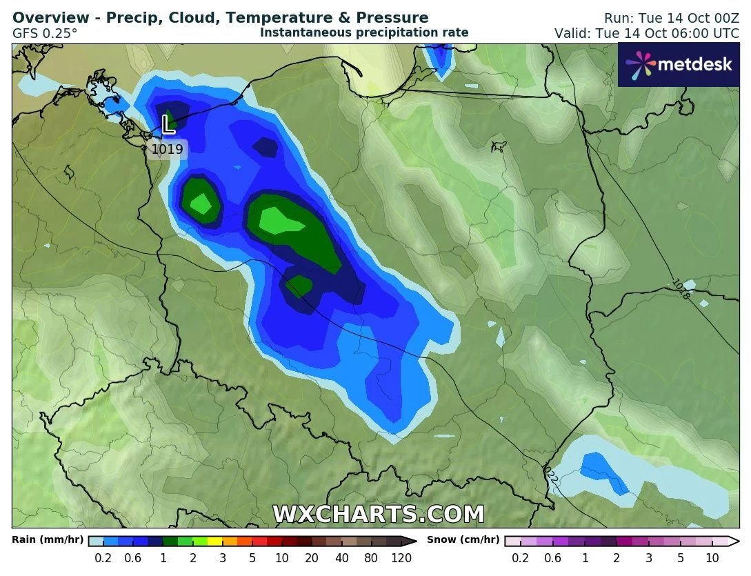 Mapa przedstawia prognozę opadów dla Polski i okolic, z intensywną strefą deszczu zaznaczoną w kolorach niebieskim oraz zielonym w centrum i na północnym zachodzie kraju, wraz z oznaczoną strefą niskiego ciśnienia atmosferycznego.