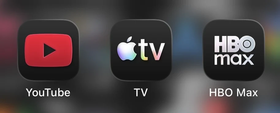 Apple TV ma nową ikonkę. Logotypy trzech aplikacji streamingowych: YouTube w czerwono-czarnej kolorystyce, TV firmy Apple w czarnej tonacji z kolorowym symbolem oraz HBO Max w czerni i bieli, wszystkie na rozmytym tle.