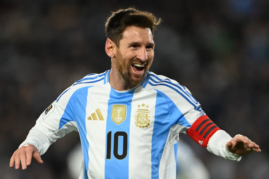 Lionel Messi we wtorek pobił kolejny historyczny rekord Piłkarz w stroju reprezentacji Argentyny z numerem 10 i opaską kapitana na ramieniu śmieje się szeroko, unosząc ręce w geście radości, w tle rozmyte sylwetki stadionu i kibiców.