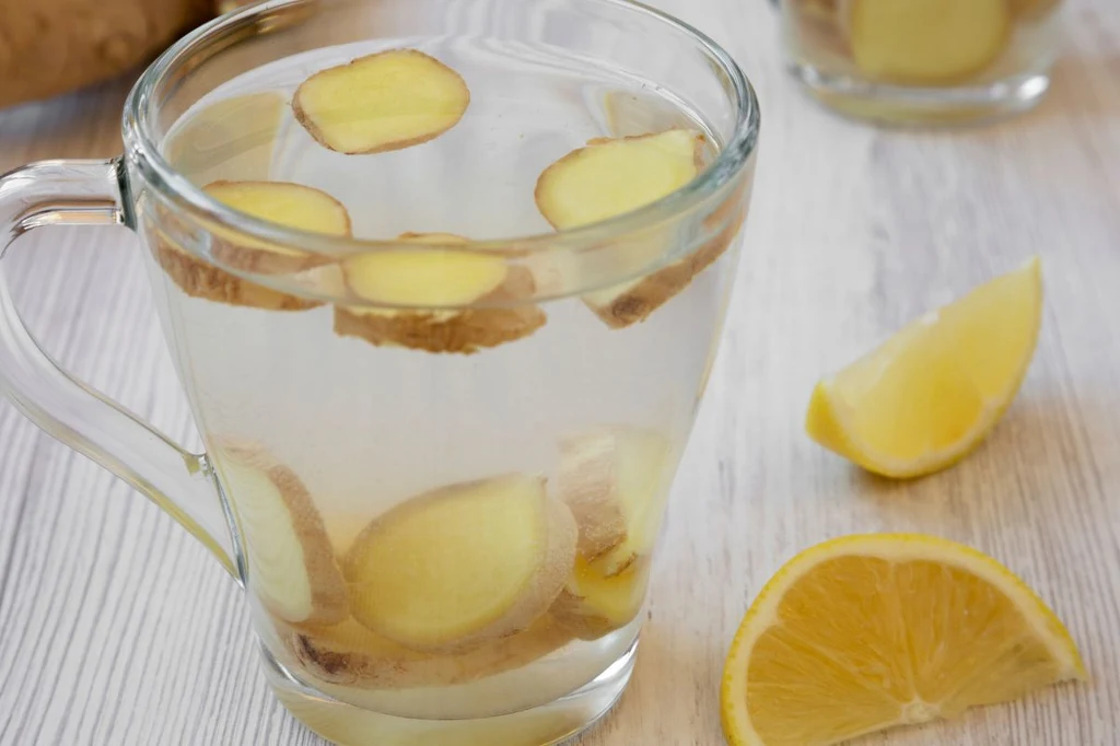 Imbir w Polsce cieszy się coraz większą popularnością, zwłaszcza jesienią i zimą Szklanka wody z plasterkami imbiru oraz pokrojoną w plasterki cytryną