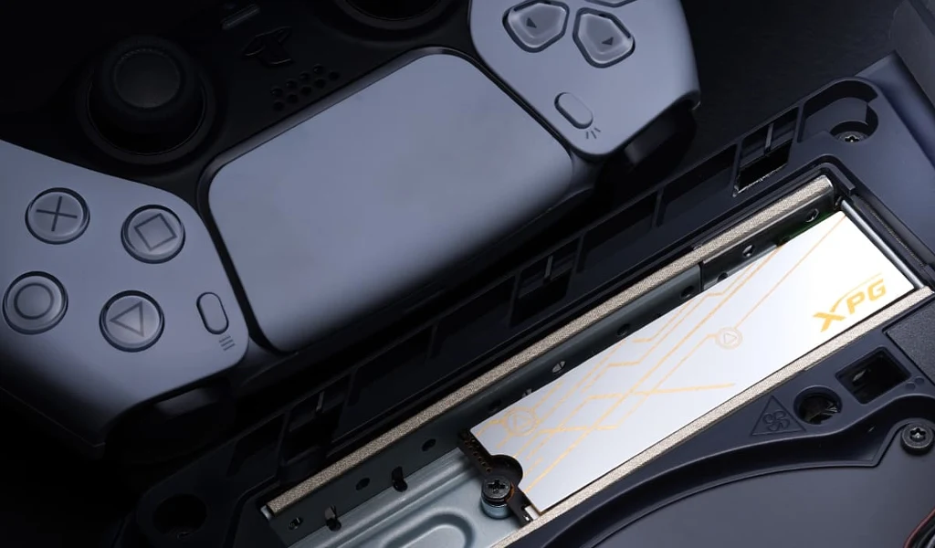 Kontroler do konsoli PlayStation umieszczony obok otwartego slotu na dysk SSD marki XPG w konsoli.