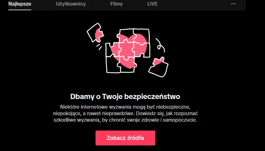 Odnośnik do materiałów edukacyjnych, który wyświetla się przy próbie wyszukania zablokowanych treści. Układanka z różowymi elementami w kształcie serca, otoczona kilkoma rozproszonymi częściami na czarnym tle, centralnie umieszczony biały napis informuje o zachowaniu bezpieczeństwa w internecie, pod spodem czerwony przycisk z napisem 'Zobacz źródła'.