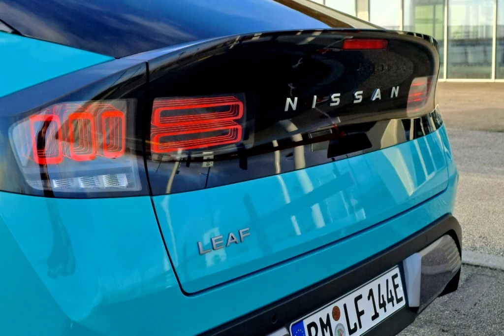 Tylne światła Leafa nawiązują do Nissana Z. Tył niebieskiego samochodu marki Nissan Leaf, widoczny napis Nissan na czarnej klapie bagażnika, nowoczesne lampy tylne oraz niemiecka tablica rejestracyjna.