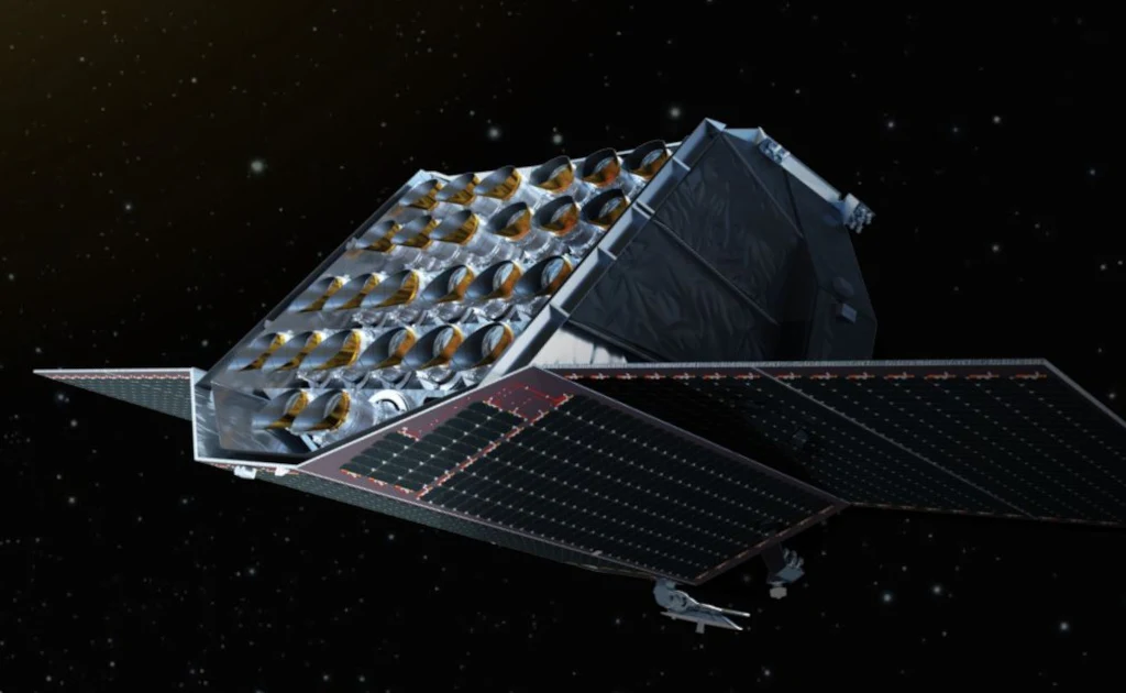 Nowoczesny satelita z rozłożonymi panelami słonecznymi unosi się na tle ciemnej przestrzeni kosmicznej, jego konstrukcja wyróżnia się licznymi komponentami technicznymi i refleksyjną powierzchnią.