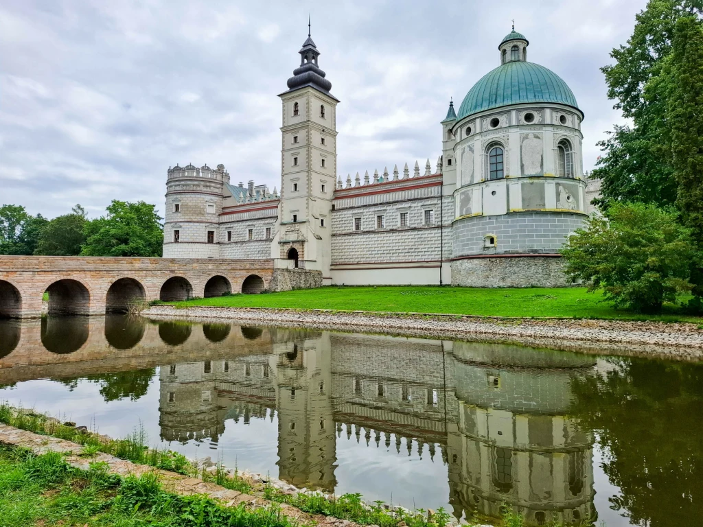 Zamek w Krasiczynie uzyskał tytuł Cudu Polski 2025 w plebiscycie National Geographic Renesansowy zamek z charakterystyczną wieżą oraz okrągłą kopułą odbijający się w wodzie fosy, otoczony zielenią i historycznym mostem z kamiennymi łukami.