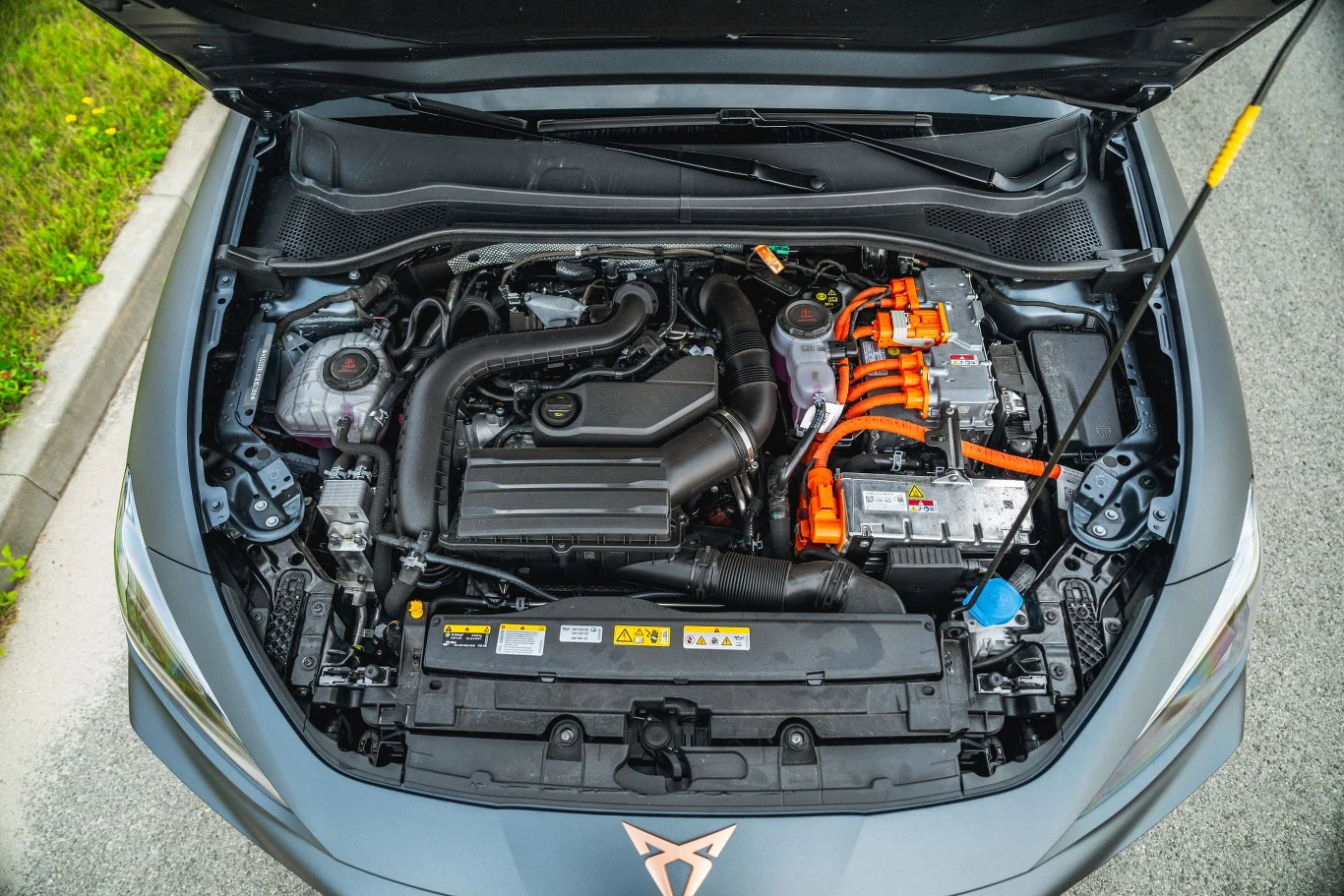 Po modernizacji silnik 1,4 w hybrydzie plug-in Cupry Leon zastąpiła jednostka 1,5 l. Silnik hybrydowy z widocznymi podzespołami elektrycznymi oznaczonymi pomarańczowymi przewodami, licznymi zbiornikami płynów i elementami osłonowymi pod maską samochodu.