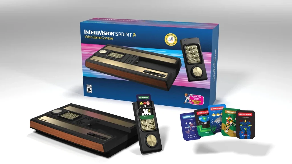 Konsola do gier wideo Intellivision Sprint wraz z opakowaniem, dwoma kontrolerami oraz zestawem kilku kolorowych kart z grafikami gier.