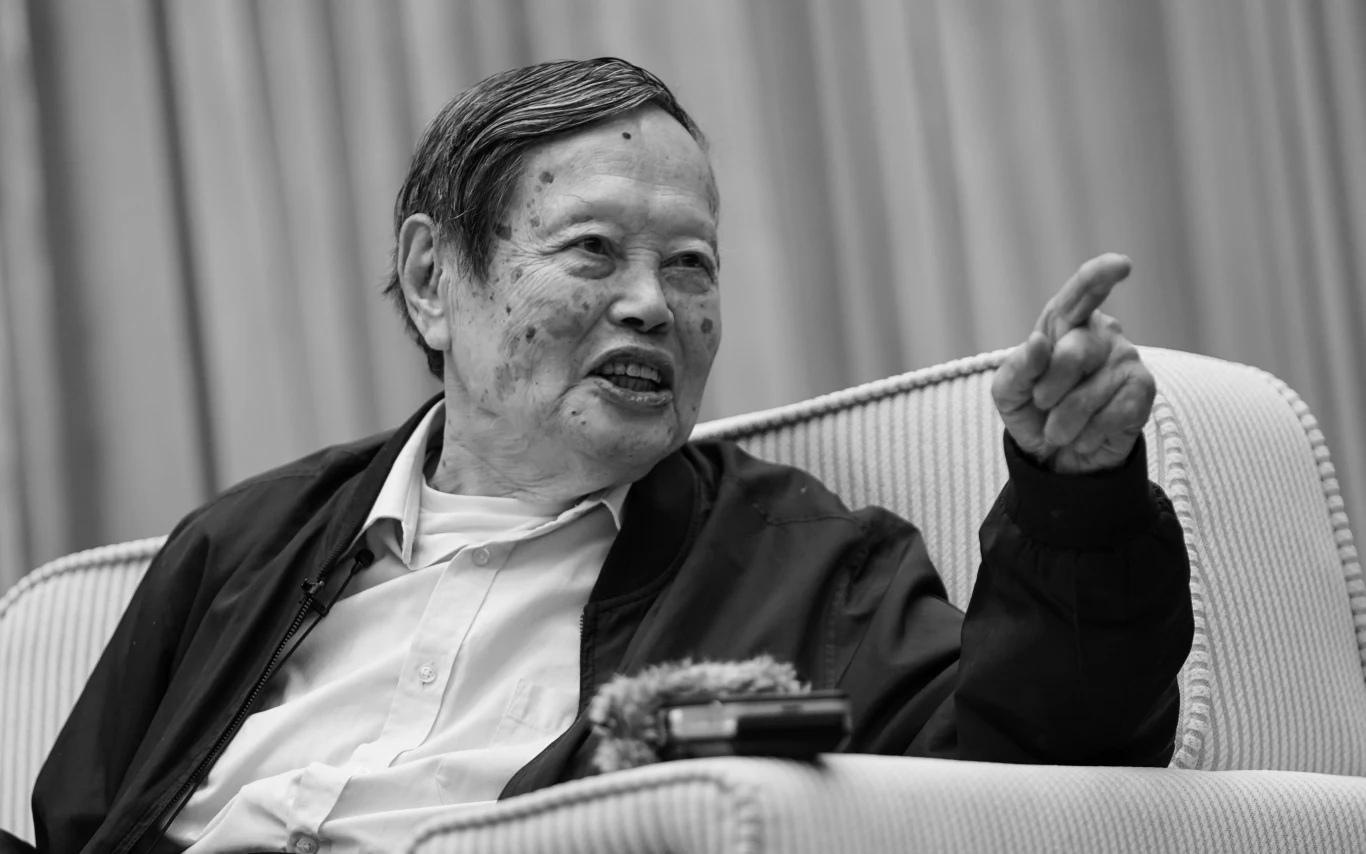 Zmarł Chen Ning Yang, laureat Nobla i twórca wielu teorii będących podstawą współczesnej nauki Starszy mężczyzna siedzi na fotelu, uśmiecha się i wskazuje palcem w prawo. Ubrany jest w jasną koszulę oraz ciemną kurtkę. W tle delikatnie rozmyte zasłony.