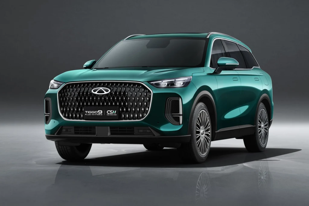 Chery Tiggo 9 w Polsce wyposażone będzie w układ hybrydowy typu plug-in generujący 428 KM mocy systemowej. Nowoczesny, zielony SUV marki Chery Tiggo 8 Pro stoi na gładkiej powierzchni, podświetlony neutralnym światłem w minimalistycznym tle, wyróżnia się dużym grillem, eleganckimi reflektorami oraz sportowymi felgami.