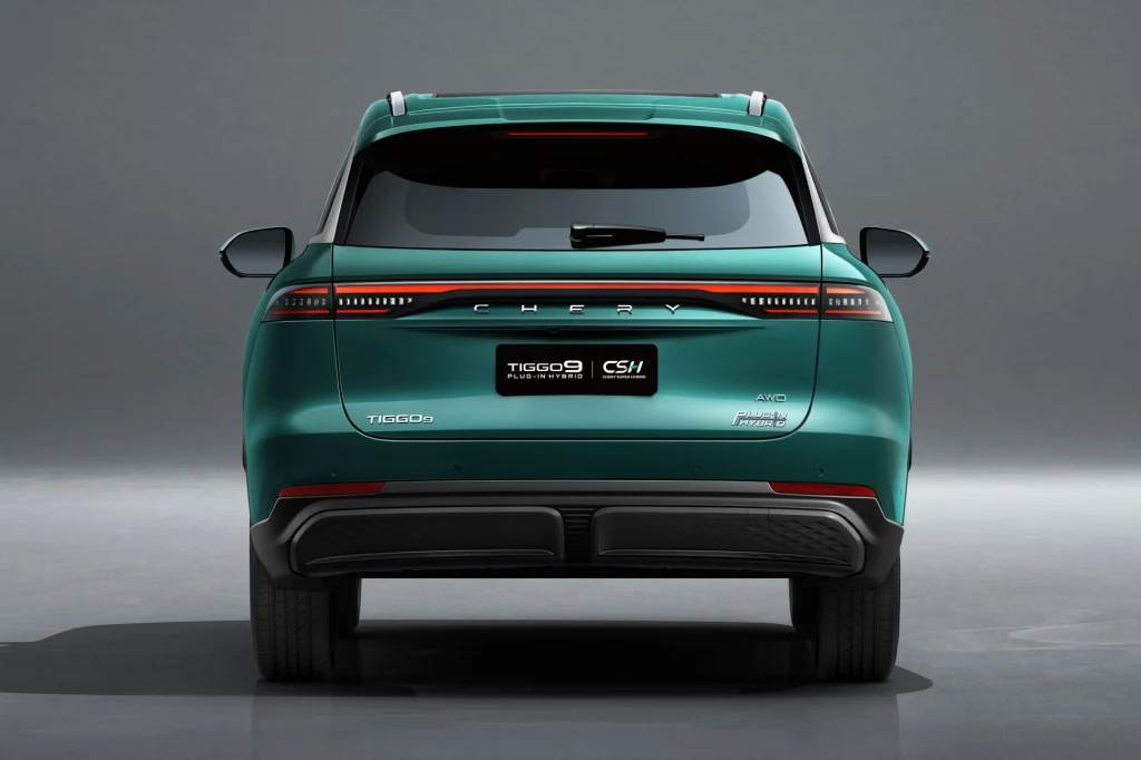 Chery Tiggo 9 w Polsce kosztuje 209 900 zł. Zielony samochód osobowy typu SUV marki Chery Tiggo 9 ustawiony tyłem, na szarym tle studyjnym, z widocznymi światłami tylnymi, emblematami marki oraz modelu.