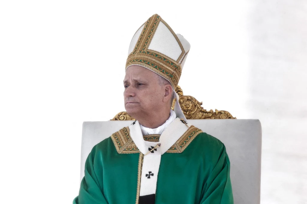 Papież Leon XIV spotkał się z ofiarami księży Mężczyzna w zielonej szacie liturgicznej i mitrze siedzi na ozdobionym złotem tronie, mając poważny wyraz twarzy.