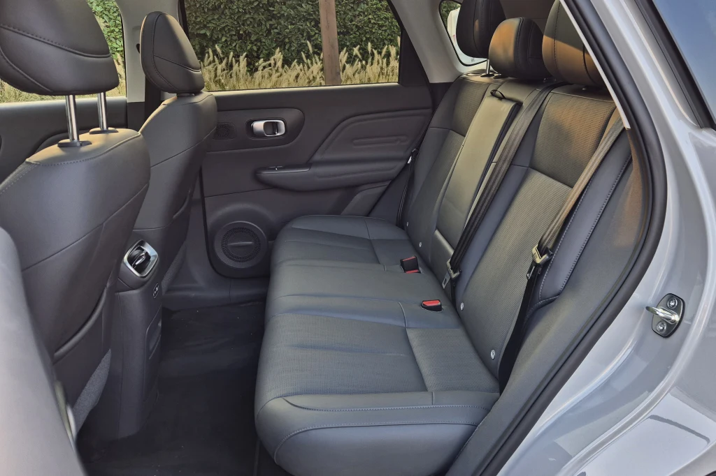 Leapmotor B10 zapewnia naprawdę dużo miejsca na tylnej kanapie Tylny rząd siedzeń samochodu z czarną tapicerką skórzaną, widoczne trzy miejsca siedzące, zagłówki oraz detale wnętrza pojazdu, jak boczki drzwiowe i nawiewy powietrza.