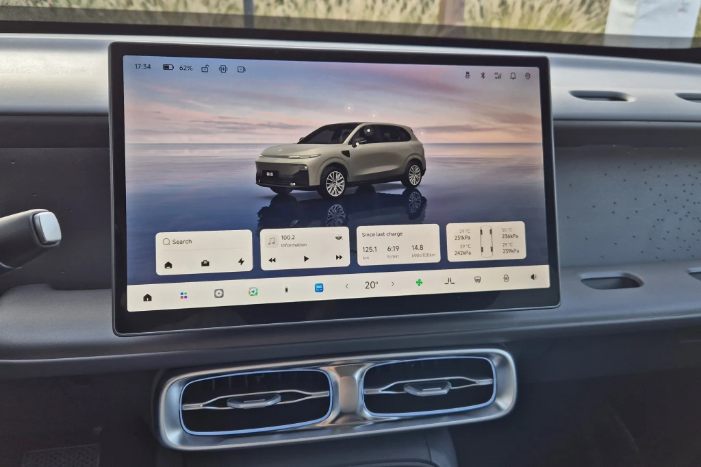 Ekran o przekątnej 14,6 cala robi bardzo dobre wrażenie Duży ekran dotykowy we wnętrzu nowoczesnego samochodu wyświetla interfejs systemu multimedialnego z wizualizacją samochodu oraz informacjami o stanie pojazdu, klimatyzacji i multimediach. Poniżej ekranu widoczne nawiewy wentylacyjne.