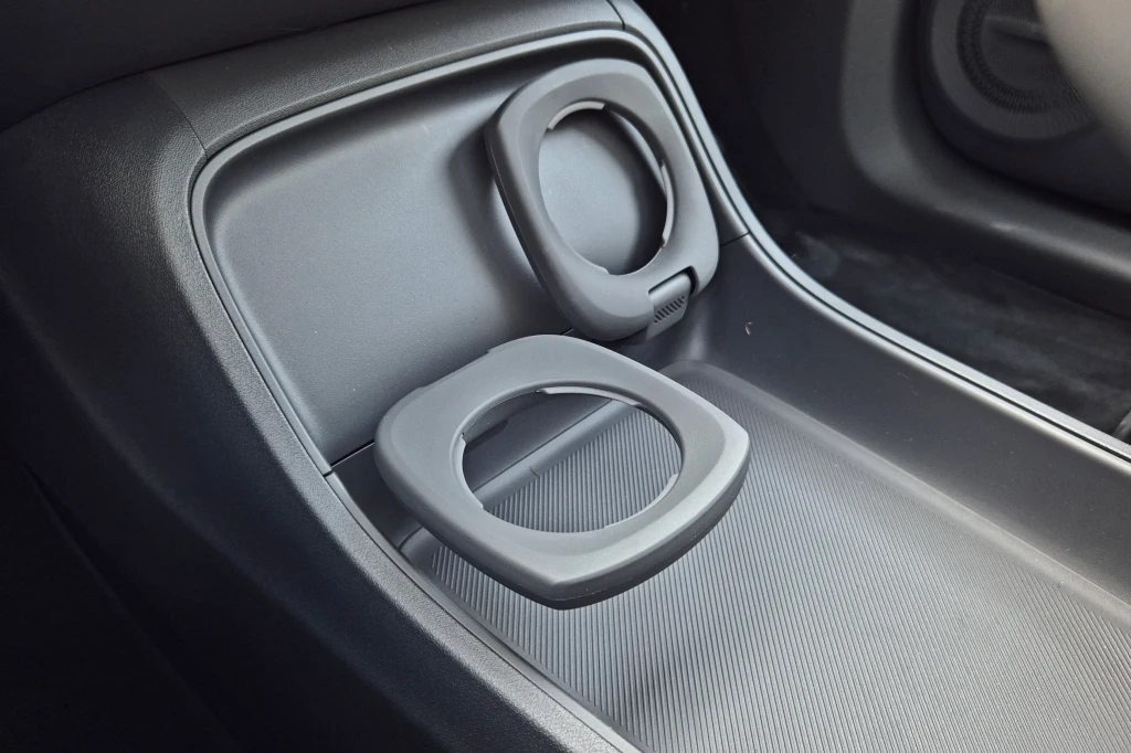 Leapmotor B10 Składany uchwyt na kubek zamontowany w konsoli środkowej samochodu, wykonany z ciemnego tworzywa, z widocznymi matowymi strukturami powierzchni