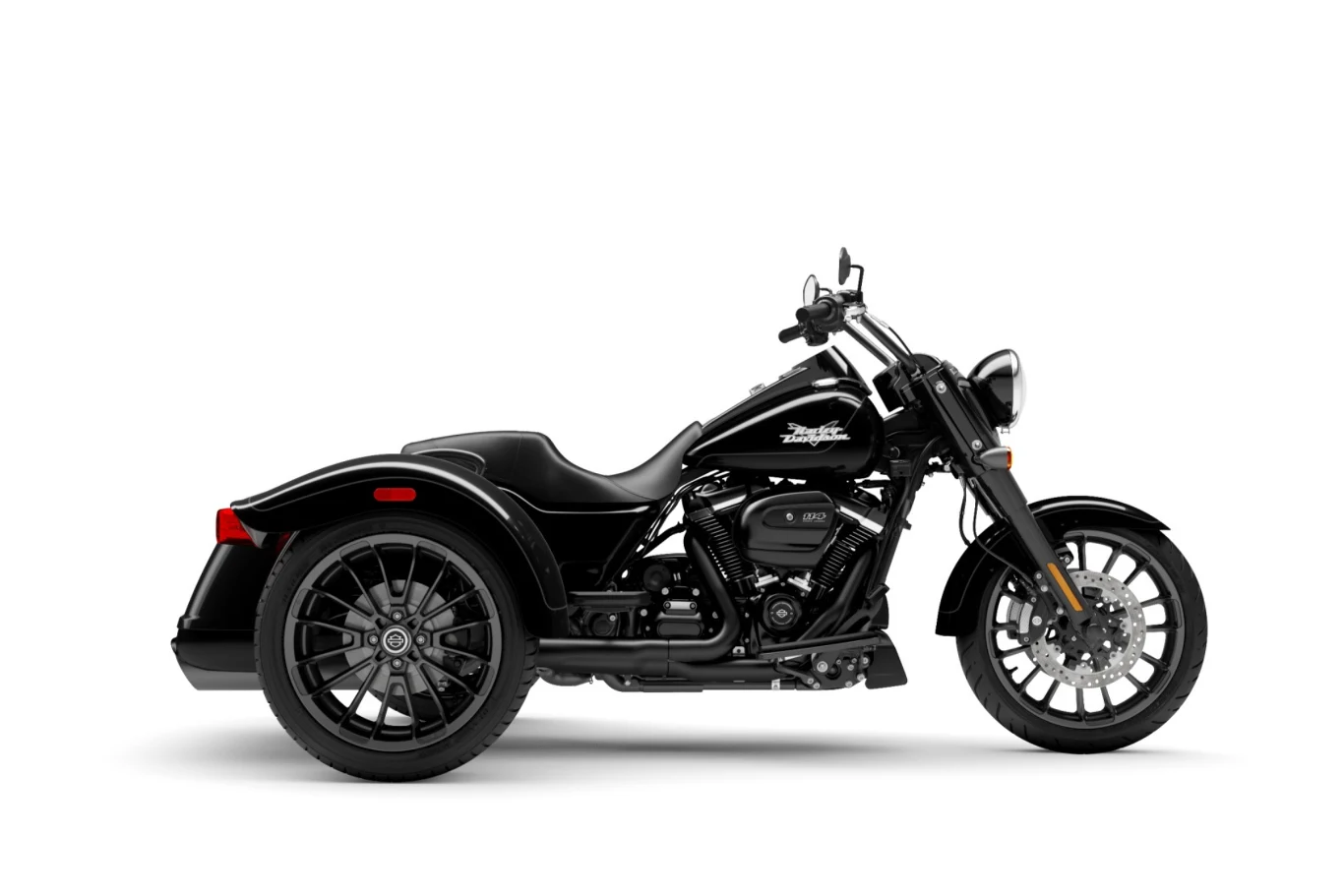 Czarny trójkołowy motocykl typu cruiser z eleganckimi detalami i dużymi kołami, osadzony na białym tle.