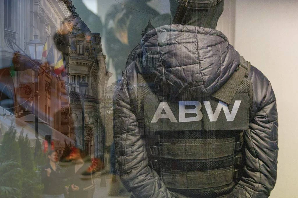Funkcjonariusz służb w kurtce z napisem ABW na plecach, stojący tyłem, na tle miejskich budynków oraz flag państwowych, elementy zdjęcia nałożone na siebie tworzą wrażenie połączenia działań służb specjalnych z miejskim otoczeniem.