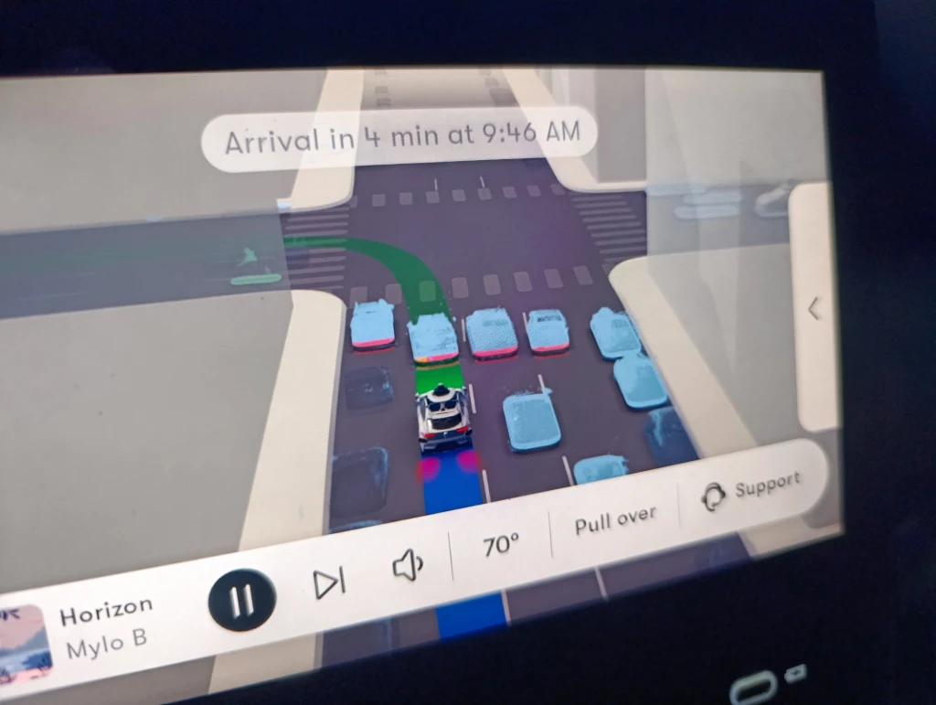 Podczas jazdy taksówka Waymo sama wyświetla co widzi na drodze Interfejs systemu nawigacji samochodowej pokazujący symulowany widok ulicy z kilkoma pojazdami, trasą przejazdu oraz szczegółami dotyczącymi przejazdu, jak czas przyjazdu i sterowanie multimediami.