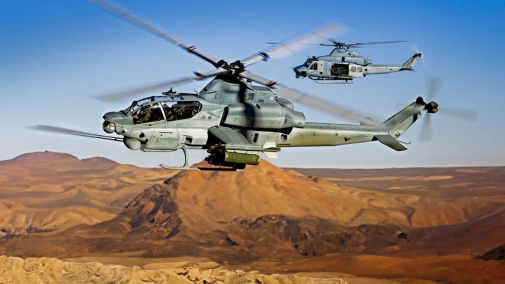 Stany Zjednoczone gotowe dostarczyć Ukrainie śmigłowce Viper i Venom Dwa wojskowe śmigłowce bojowe lecą nad pustynnym, górzystym terenem przy błękitnym niebie, pierwsza maszyna dominuje ujęcie z wyraźnie widocznymi szczegółami kadłuba i uzbrojenia.