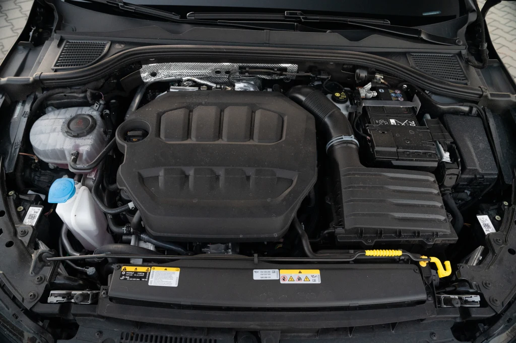 Pod maską Golfa R pracuje doskonale znana jednostka 2.0 TSI, którą po liftingu wzmocniono do 333 KM Silnik samochodowy umieszczony w komorze, widoczna pokrywa silnika, bateria akumulatora po prawej stronie, przewody, zbiornik płynu chłodniczego po lewej oraz elementy instalacji elektrycznej i chłodniczej.